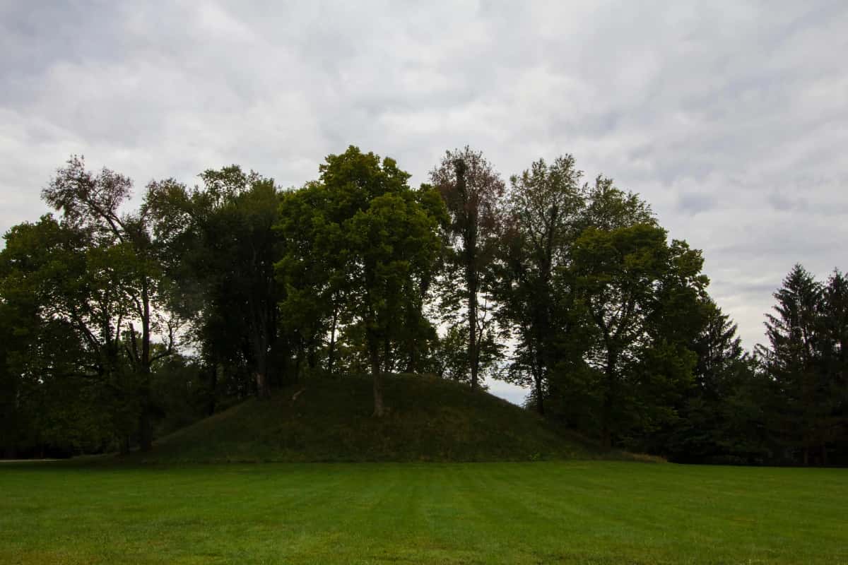 A grassy mound called jeffers mound in worthington ohio with a cloudy sky