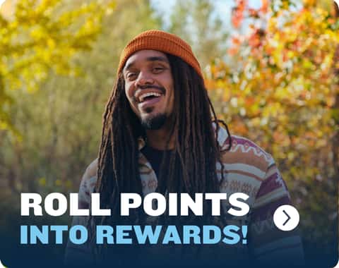 Smiling person with long dreadlocks and orange beanie in a colorful autumn setting. Text reads, "Roll Points into Rewards!"