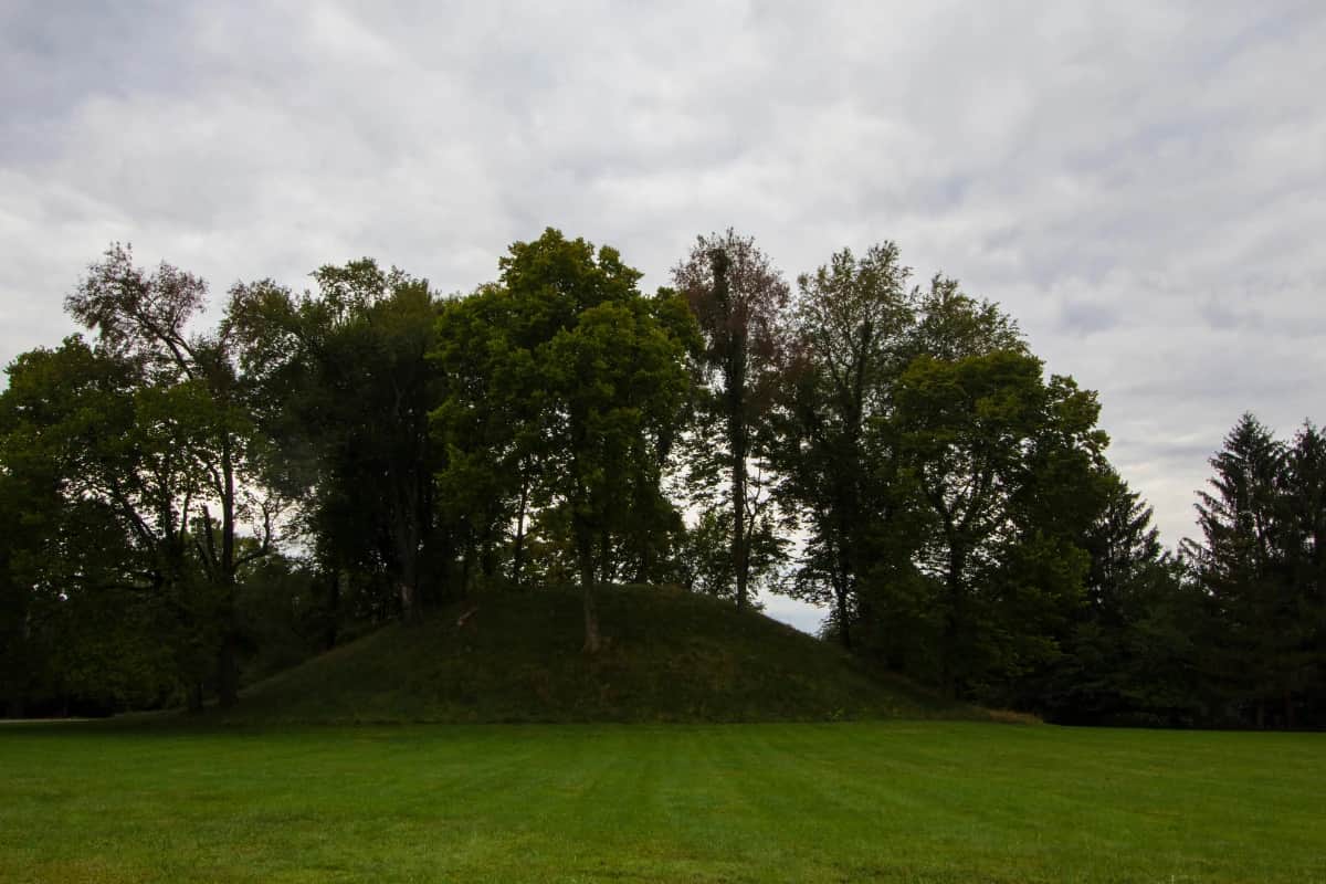 A grassy mound called jeffers mound in worthington ohio with a cloudy sky